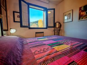 Un dormitorio con una cama grande con ventana. en Confort excelente- Chimenea, sol y bien equipado - Falcó 10, en Pla de l'Ermita