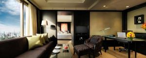 a living room with a couch and a desk at Banyan Tree Bangkok in Bangkok