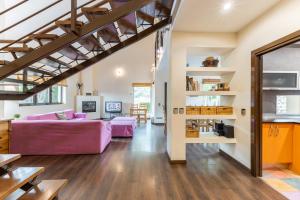 Una sala de estar con una cama morada y un loft. en El Herrén Del Abuelo, en Vegas de Matute