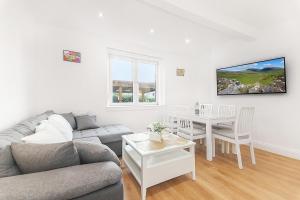 a living room with a couch and a table at Private Hot Tub - Garden - Free Parking -2bdrm - 5ppl - Zen & Bubbles in Edinburgh