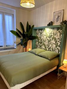 een slaapkamer met een groot bed met een groen hoofdeinde bij L'Oxygène -400m de la gare in Saint-Brieuc