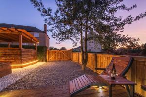 a patio with a wooden bench and a tree at Private Hot Tub - Garden - Free Parking -2bdrm - 5ppl - Zen & Bubbles in Edinburgh