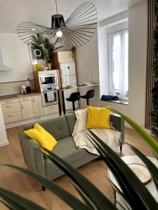 een woonkamer met een grijze bank en gele kussens bij L'Oxygène -400m de la gare in Saint-Brieuc