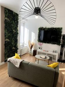 een woonkamer met een bank en een tv bij L'Oxygène -400m de la gare in Saint-Brieuc