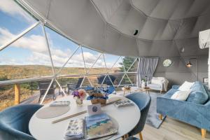 a room with a table and chairs in a boat at Barrel Hot Tub at 'The Eagle Dome' in Franklin in Franklin