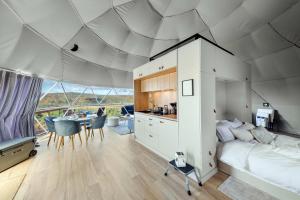 a bedroom with a bed and a kitchen with a table at Barrel Hot Tub at 'The Eagle Dome' in Franklin in Franklin