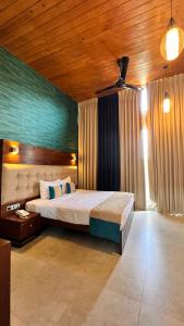 a bedroom with a large bed and a wooden ceiling at Avanee Hotel in Mawanella