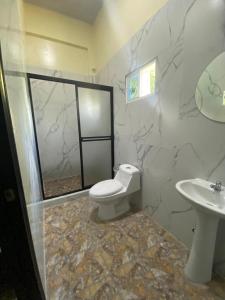 a bathroom with a toilet and a sink at Kosta Brava Hotel y Restobar in El Majahual +3 photos