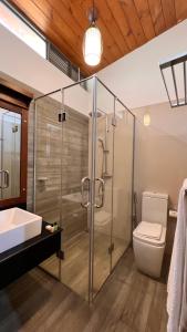 a bathroom with a shower and a toilet and a sink at Avanee Hotel in Mawanella +19 photos