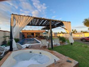 a hot tub in a backyard with a pergola at Quinta Los Castillos in Itá
