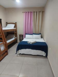 a bedroom with a bed with a blue comforter at Quinta Los Castillos in Itá