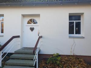 ein weißes Haus mit einer Tür, auf der ein Herz abgebildet ist in der Unterkunft Auf dem Bauernhof  + 3 Fotos