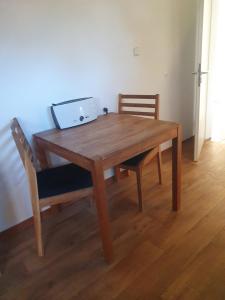 einem Holztisch mit zwei Stühlen und einem Laptop darauf in der Unterkunft Auf dem Bauernhof 