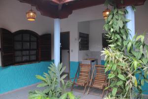 une terrasse couverte avec des chaises et des plantes dans l'établissement Azular Ubatuba - Eco Vila, Casas, Bangalôs, Yoga & Surf Inn, à Ubatuba