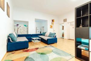 Una sala de estar con un sofá azul y una alfombra. en City Center Studio, en Graz