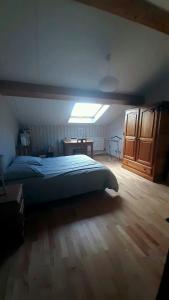 ein Schlafzimmer mit Bett, Schreibtisch und Fenster in der Unterkunft Chambre de 15m2 à la campagne avec salle de bains in Vacqueville