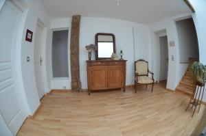 einen Flur mit einem Spiegel und einer Holzkommode in der Unterkunft Chambre de 15m2 à la campagne avec salle de bains in Vacqueville