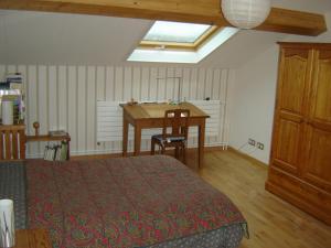 ein Schlafzimmer mit einem Bett und einem Tisch und einem Fenster in der Unterkunft Chambre de 15m2 à la campagne avec salle de bains in Vacqueville + 3 Fotos