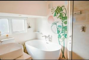 Un baño con lavabo blanco y ducha en Puka Mala Tiny House, en Ciudad del Cabo