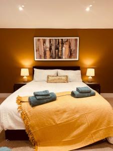 a bedroom with a large bed with two towels on it at LivinSpace- Modern and spacious 2 bed flat in Central Sutton in Sutton