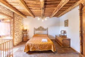ein Schlafzimmer mit einem Bett und einer Holzdecke in der Unterkunft La Botica De Maderuelo in Maderuelo