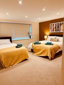 two beds in a room with yellow blankets at LivinSpace- Modern and spacious 2 bed flat in Central Sutton in Sutton