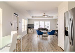 eine Küche und ein Wohnzimmer mit einem Tisch und blauen Stühlen in der Unterkunft Blue Lagoon with Hot Tub and Golf Cart! in Bolivar Peninsula