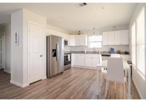 eine Küche mit weißen Schränken und einem Edelstahlkühlschrank in der Unterkunft Blue Lagoon with Hot Tub and Golf Cart! in Bolivar Peninsula