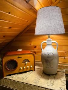 Una lámpara sobre una mesa junto a un altavoz y un jarrón. en Historic Sadie's Log Cabin, en McGregor 2 fotos más
