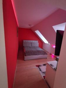 a bedroom with a bed and a red wall at KissApartman in Kőszeg