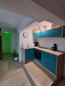 a kitchen with blue cabinets and a sink at KissApartman in Kőszeg