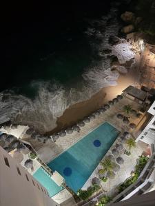 mit Blick auf den Pool und das Meer in der Unterkunft Hermosa Suite a Pie de Playa en Acapulco in Acapulco