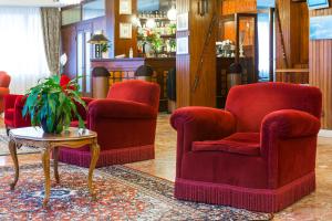 a living room filled with furniture and a red chair at Hotel Rigel in Venice-Lido