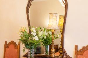 a mirror with two vases and a lamp and flowers at Hotel Rigel in Venice-Lido