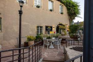 patio exterior de un edificio con mesa y sillas en Hotel Restaurant L'Orchidee, en Ensisheim