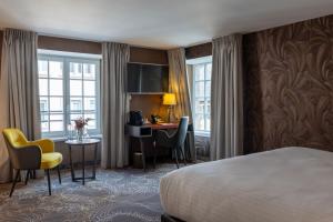 una habitación de hotel con una cama y un escritorio en Hotel Restaurant L'Orchidee, en Ensisheim