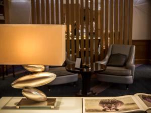 a lamp on a table in a living room with a chair at Sofitel Beirut Le Gabriel in Beirut