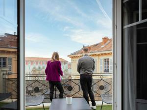 a man and woman standing on a balcony looking out of a window at Mercure Nice Centre Grimaldi in Nice +109 photos