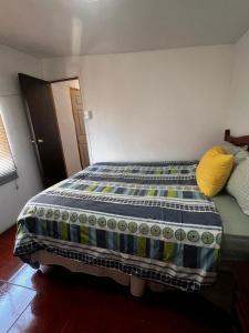 a bedroom with a bed with a blue and yellow comforter at Cabañas Costatour Quintero in Quintero +84 photos