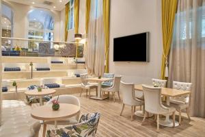 un ristorante con tavoli e sedie e una TV a schermo piatto di NH Collection Madrid Abascal a Madrid Altre 56 foto