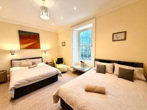 une chambre avec deux lits et une fenêtre dans l'établissement Georgian Luxury Apartment - Fast Broadband WiFi - Parking Available, à Édimbourg