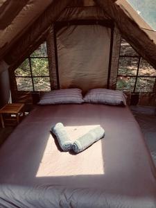 a bed in a tent with two towels on it at Bubble Paradise, Koh ta Kiev in Koh Ta kiev Island