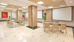 a conference room with tables and chairs and a whiteboard at NH Collection Madrid Abascal in Madrid