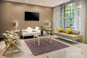 a living room with two couches and a tv at NH Collection Madrid Abascal in Madrid