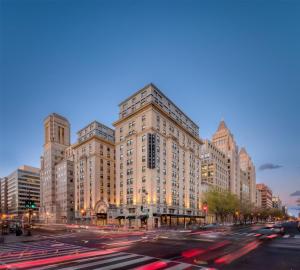 a large building on a busy city street at dusk at Hamilton Hotel - Washington DC in Washington