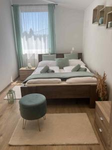 ハイドゥソボスローにあるWhite Stone Apartmanのベッドルーム(大型ベッド1台、青いオットマン付) +87枚の写真