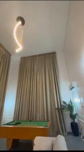 sala de estar con mesa de billar frente a una ventana en Emerald harbour apartments, en Epe 4 fotos más