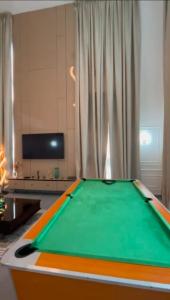 Habitación con mesa de billar frente a una ventana en Emerald harbour apartments, en Epe