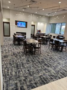 ein Esszimmer mit Tischen und Stühlen und einem Fernseher in der Unterkunft La Quinta by Wyndham New Haven in New Haven