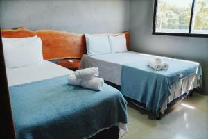 2 Betten in einem Zimmer mit Handtüchern auf den Betten in der Unterkunft Casa em Milagres| 3 suítes, área gourmet, piscina in Passo de Camarajibe + 16 Fotos